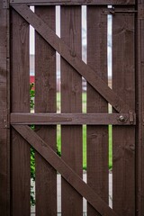 dark brown old wooden garden gate in the daytime

