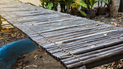 A close-up view of an old bamboo bridge screwed down.