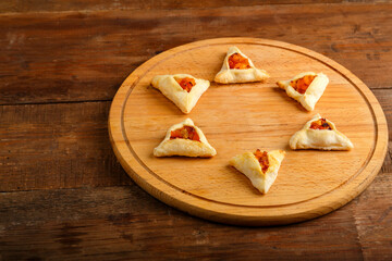 Sweet gometashi cookies for Purim laid out on a chalkboard in the shape of magen David. copy space