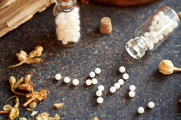 Homeopathic pills spilled from a glass bottle
