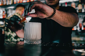man hand bartender making cocktail in glass on the bar counter