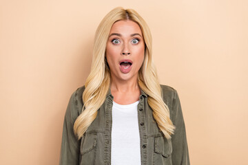 Photo of impressed shiny woman wear khaki shirt smiling open mouth isolated beige color background