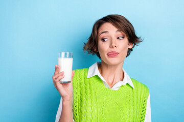 Photo of nice funny lady look hand hold fresh milk glass tongue lick lip isolated on blue color background