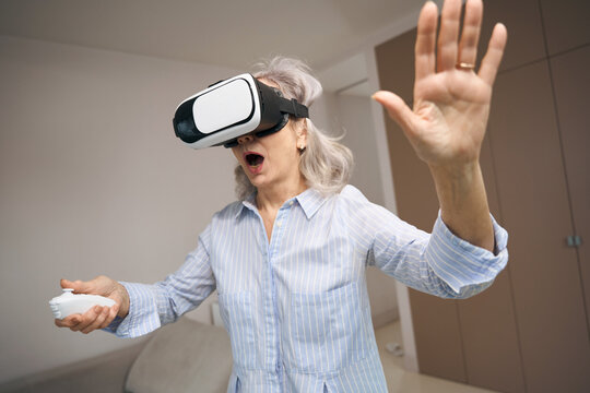 Enthusiastic senior woman is playing a virtual game
