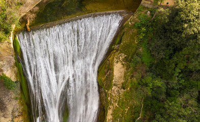 Aerial view of the Great Waterfall of Tivoli, near Rome, Italy. It is located in the park of Villa Gregoriana. Waterfall surrounded with natural cliffs and green trees. 