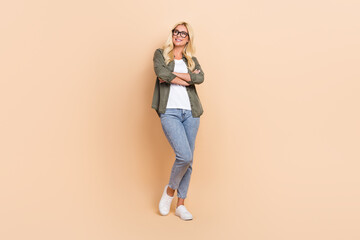 Fototapeta na wymiar Full length photo of adorable lady wear stylish clothes look up empty space banner news information isolated on beige color background