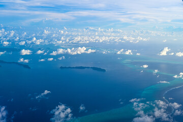 Fototapeta na wymiar Clouds in the blue sky as seen through window of an aircraft