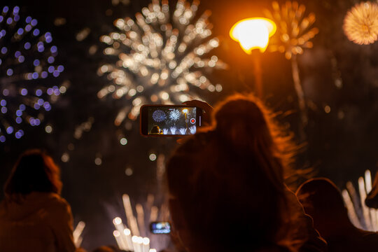 woman taking the photo of fireworks by smartphone