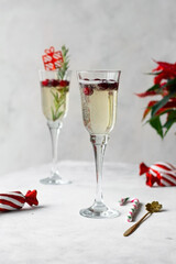 Champagne in flute glasses, Christmas decorations and poinsettia on celebration table. Happy New Year. Christmas and New Year holidays.