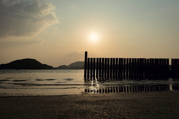 Orange sky sunset on the beach with old jetty silhouette