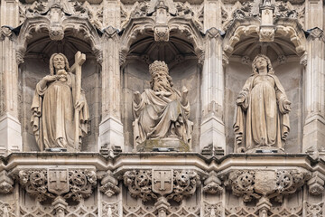 Fototapeta premium Triptych of ancient statues: God the Father, Jesus Christ, Virgin Mary. Fragment of bell tower of the Saint-Maurice church in Lille sity.