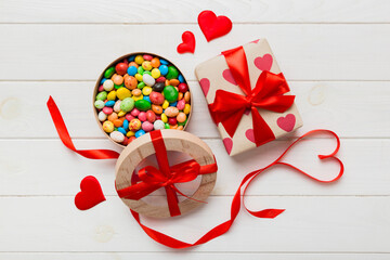 Valentine day composition: sweet candy, with gift boxes with bow and red felt hearts, photo...