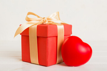 gift box with red bow and red heart on colored background. Perspective view. Flat lay