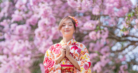 Japanese woman in traditional kimono dress is making a new year wish for good fortune while walking...