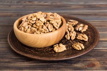 Fresh healthy walnuts in bowl on colored table background. Top view Healthy eating bertholletia concept. Super foods
