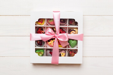 Valentine day composition: sweet candy, with gift boxes with bow and red felt hearts, photo template, background. Top View with copy space