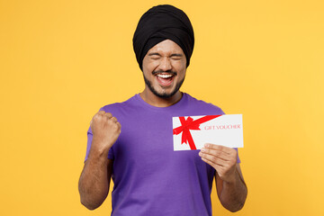 Devotee Sikh Indian man tie his traditional turban dastar wear purple t-shirt hold gift certificate...