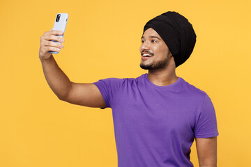 Fun devotee Sikh Indian man ties his traditional turban dastar wear purple t-shirt doing selfie...
