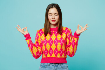 Young woman wear bright casual clothes hold spread hands in yoga om aum gesture relax meditate try to calm down isolated on plain pastel light blue cyan background studio portrait. Lifestyle concept.