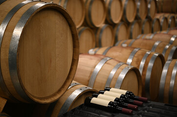 Wooden wine barrels in the cellar of the winery - 579411527