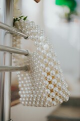 Vertical shot of a small bag woven with white pearls