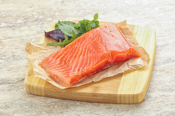 Raw salmon fillet over board