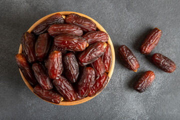 Date fruits in wooden bowl,on black background
