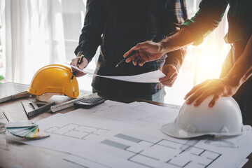 Engineers work as a team with blueprints for architectural plans. Engineer sketching construction...
