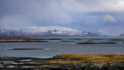 Snow covered Mountains surrounded by fjords in Norway during winter with icy mountain tops