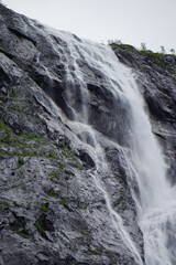 Small waterfall going down sharp stone cliffs