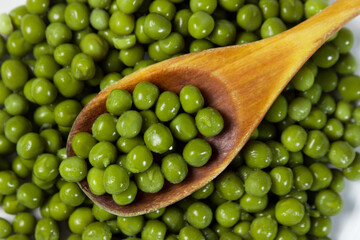 Pickled green peas on a white plate on a white background