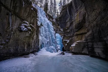  view from inside maligne river canyon on frozen waterfall with blue water © Sid Smith