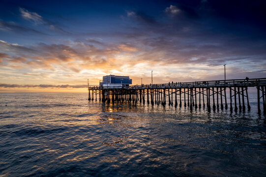 Mesmerizing scene of the pier at Newport Beach under sunset dramatic sky, California