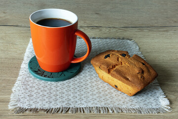 A cup of coffee with a cupcake on the table