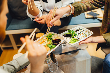 People having lunch, group of friends having sushi, eating asian food. © Aleksandrs Muiznieks
