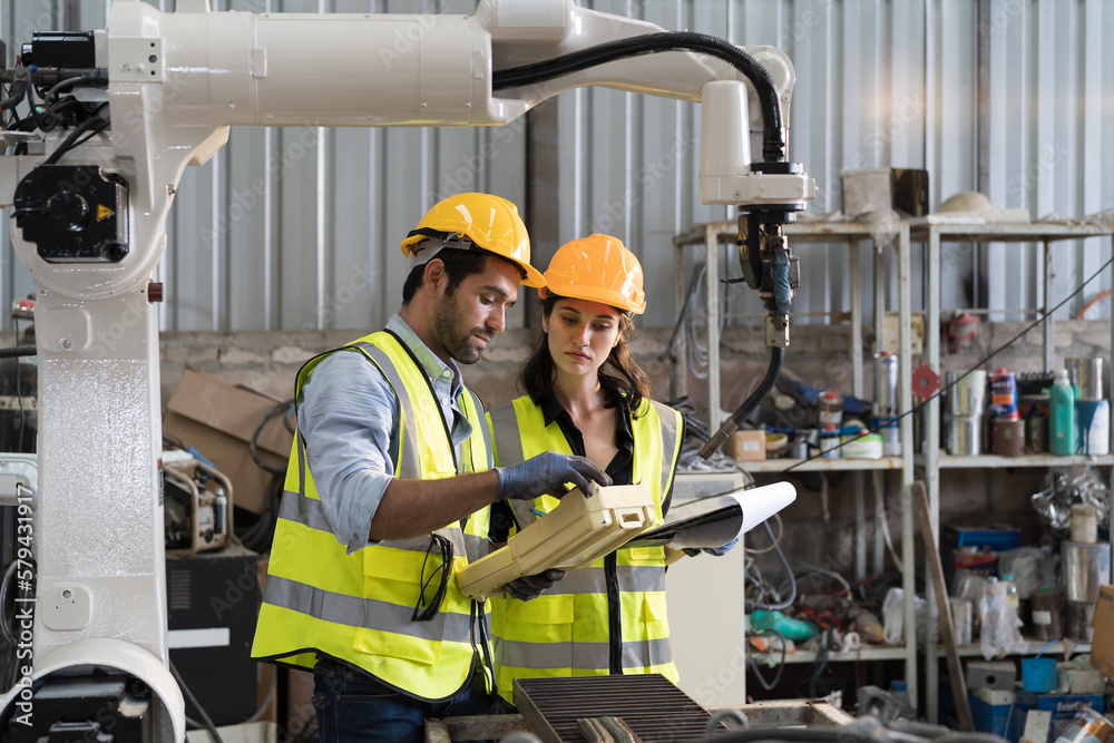 Aufkleber male and female technician control robot arm system welding with robot controller at production plan