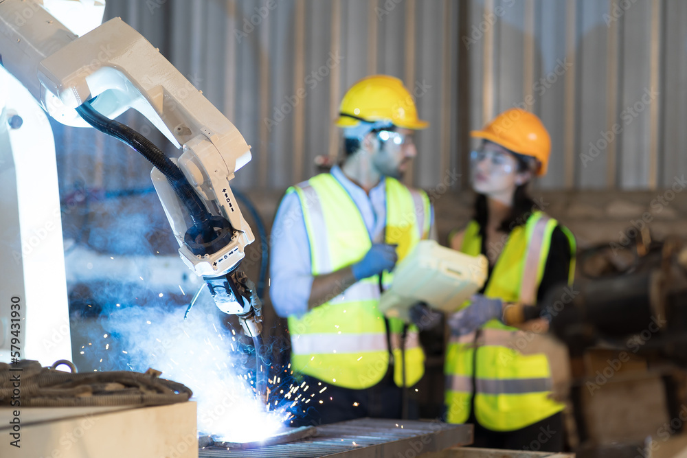 Poster male and female technician control robot arm system welding with robot controller at production plan