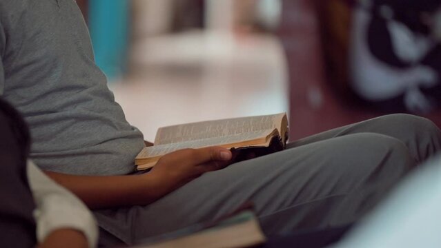 Person reading the Bible during the mass in a church