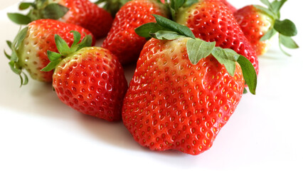 plusieurs fraises, en gros plan, isolées sur un fond blanc