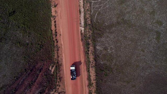 Drone view of a car driving on a curvy road in a field in Puerto Lempira, Honduras