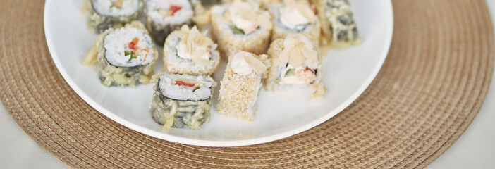 Banner of Japanese sushi rolls with raw fish. Delicious rolls are on the plate. Delicious rolls with tofu and vegetables. With space to copy. High quality photo