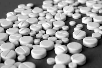 Fototapeta na wymiar White pills lie on a gray background. 