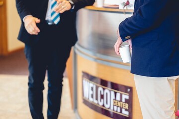 People in suits communicating at a welcome center on the entrance to an event