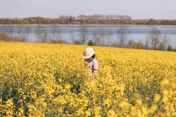 Nine year-old girl walking in a field of yellow flowers