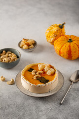 Tasty appetizing pumpkin soup with creamy silky texture decorated with seeds, nuts and croutons in camembert cheese for single serving.
