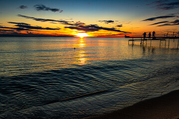 The view of the setting sun has the beaches of the Hel Peninsula in Poland.