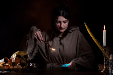 Medieval witch performs magic with magic wand and magic powder