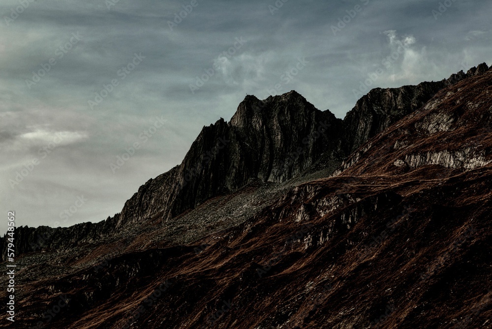 Sticker mesmerizing landscape of the rocky mountains on a dark cloudy day