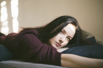 Young Female Daydreaming While Looking Out Of The Window