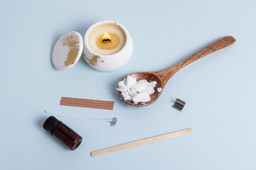 Candle making kit on blue background. Wax, candle, wick and aroma oil. Creating an aromatic candle